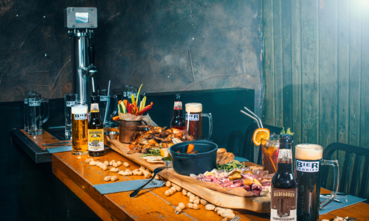 Tafel vol bier, kippetjes pinda's en bier bij Bierfabriek Amsterdam